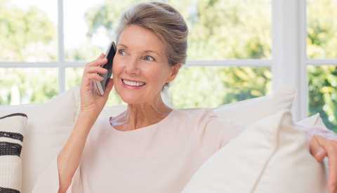 woman seated on the couch on the phone